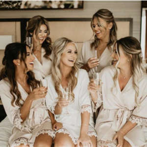 bride and bridesmaids dressed in white and pink bridal robes