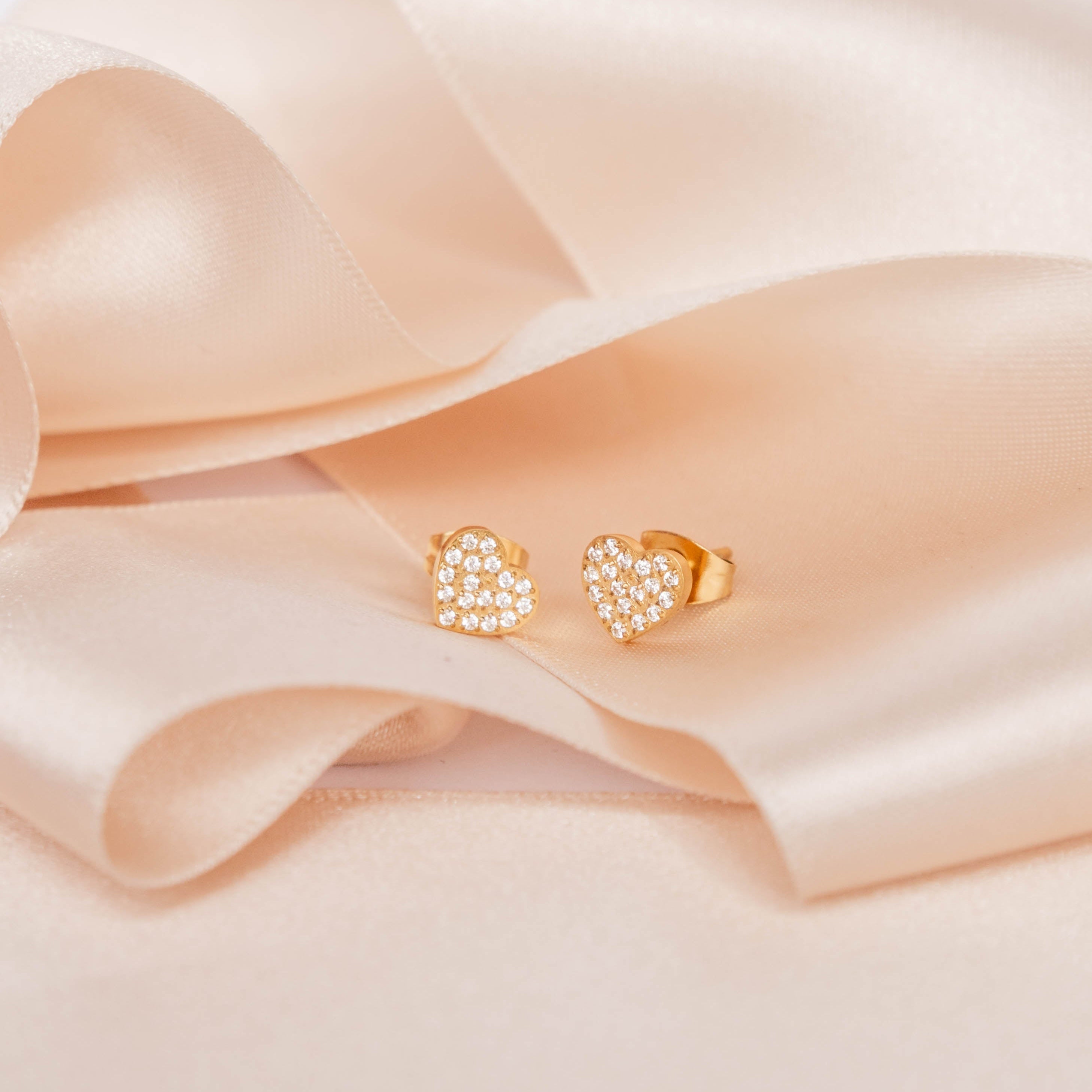 Heart-shaped earrings on a soft pink satin ribbon