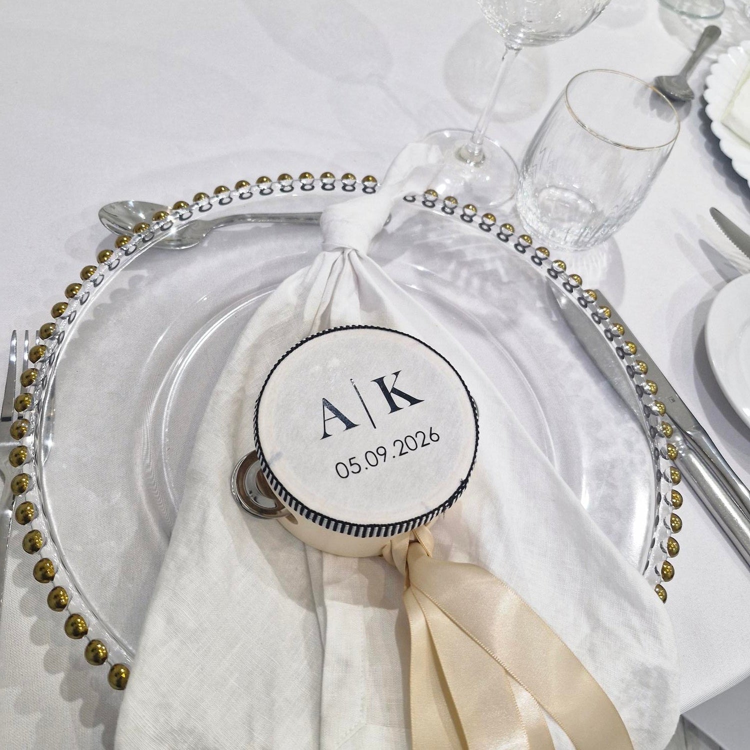 Decorative table setting with a personalised tambourine on a white plate.
