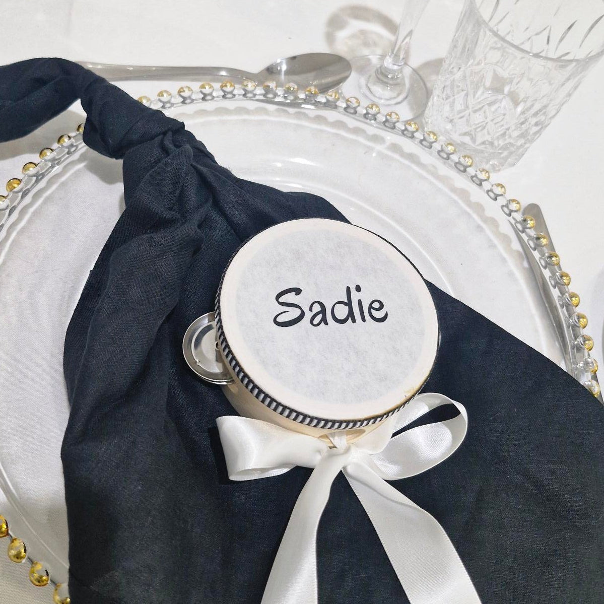 Napkin holder with 'Sadie' on a tambourine on a decorative table setting