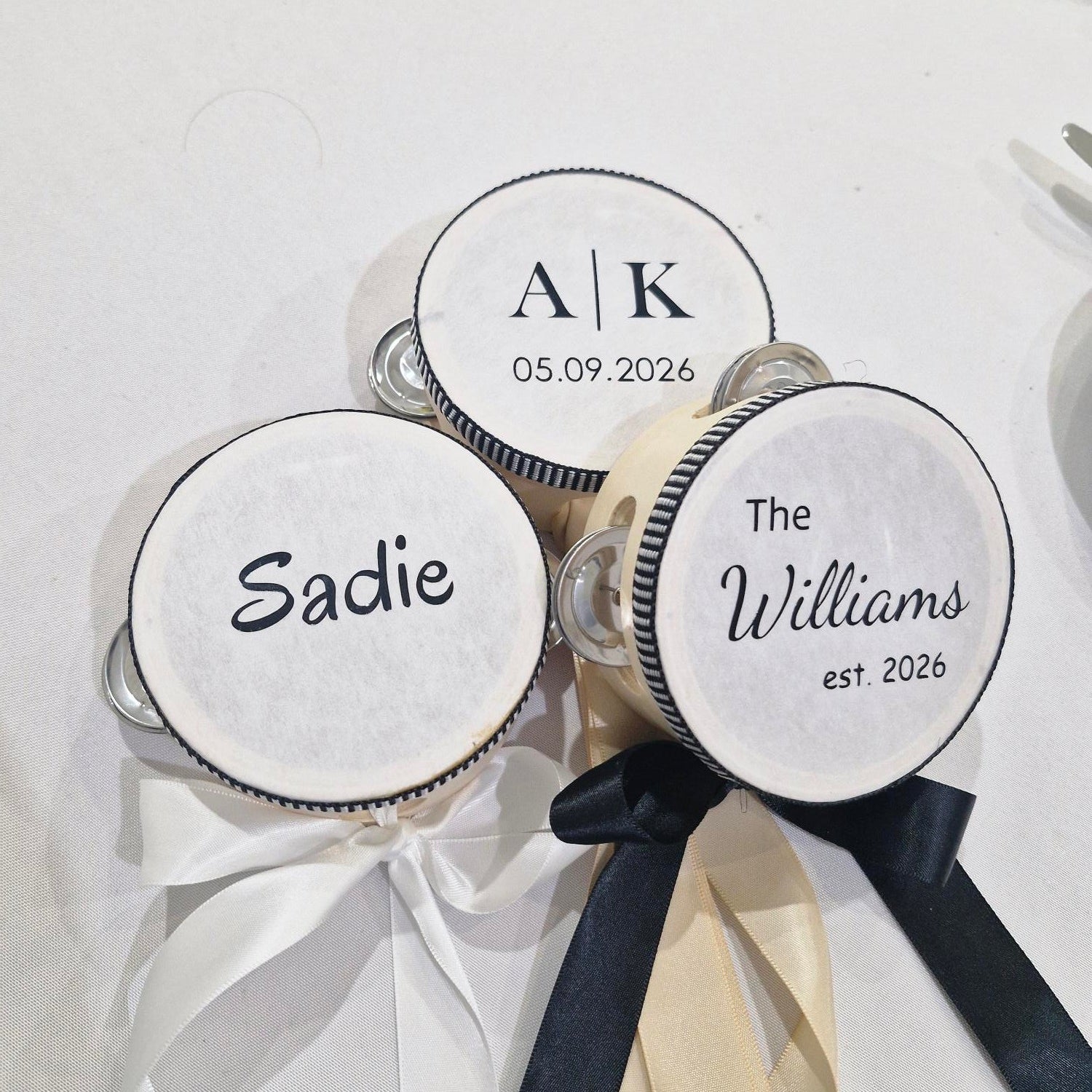 Personalised tambourines with names and dates on a white background