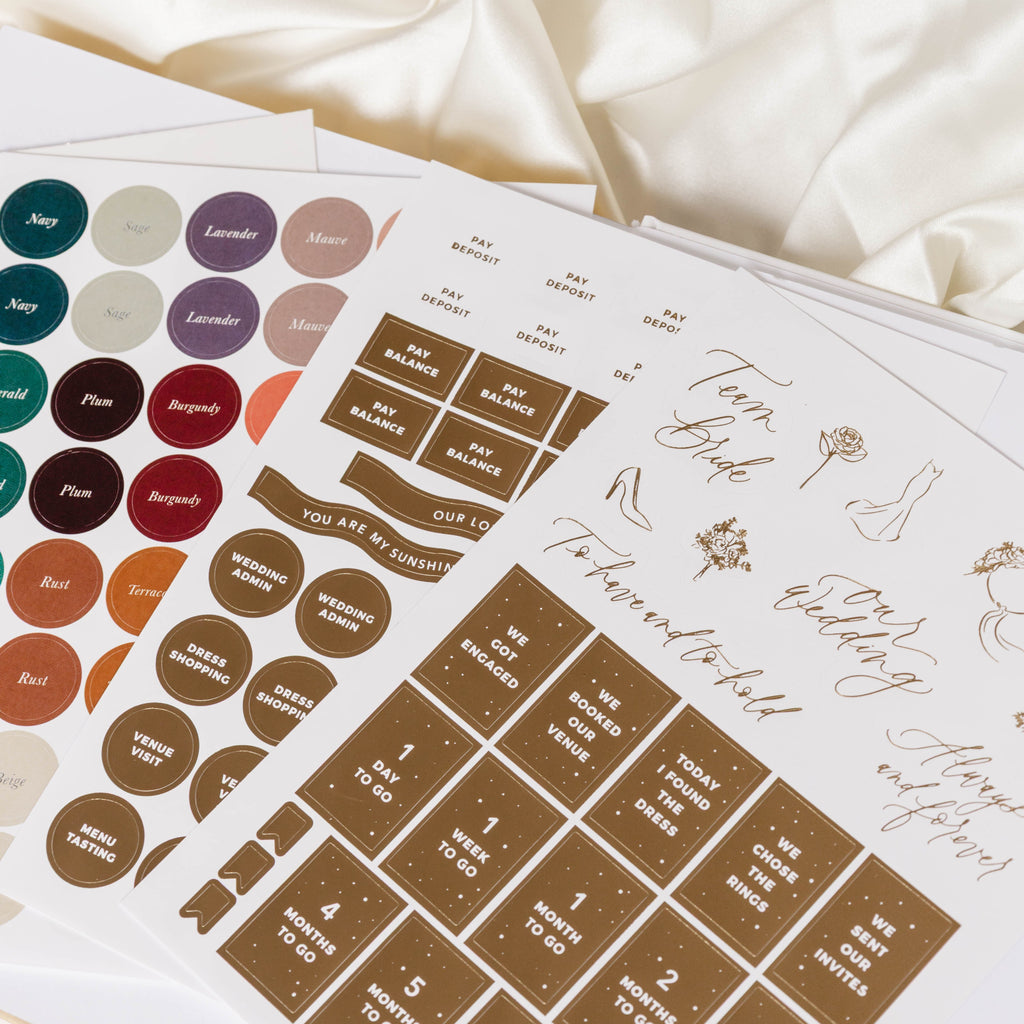 Sheet of decorative stickers with various designs on a white fabric background