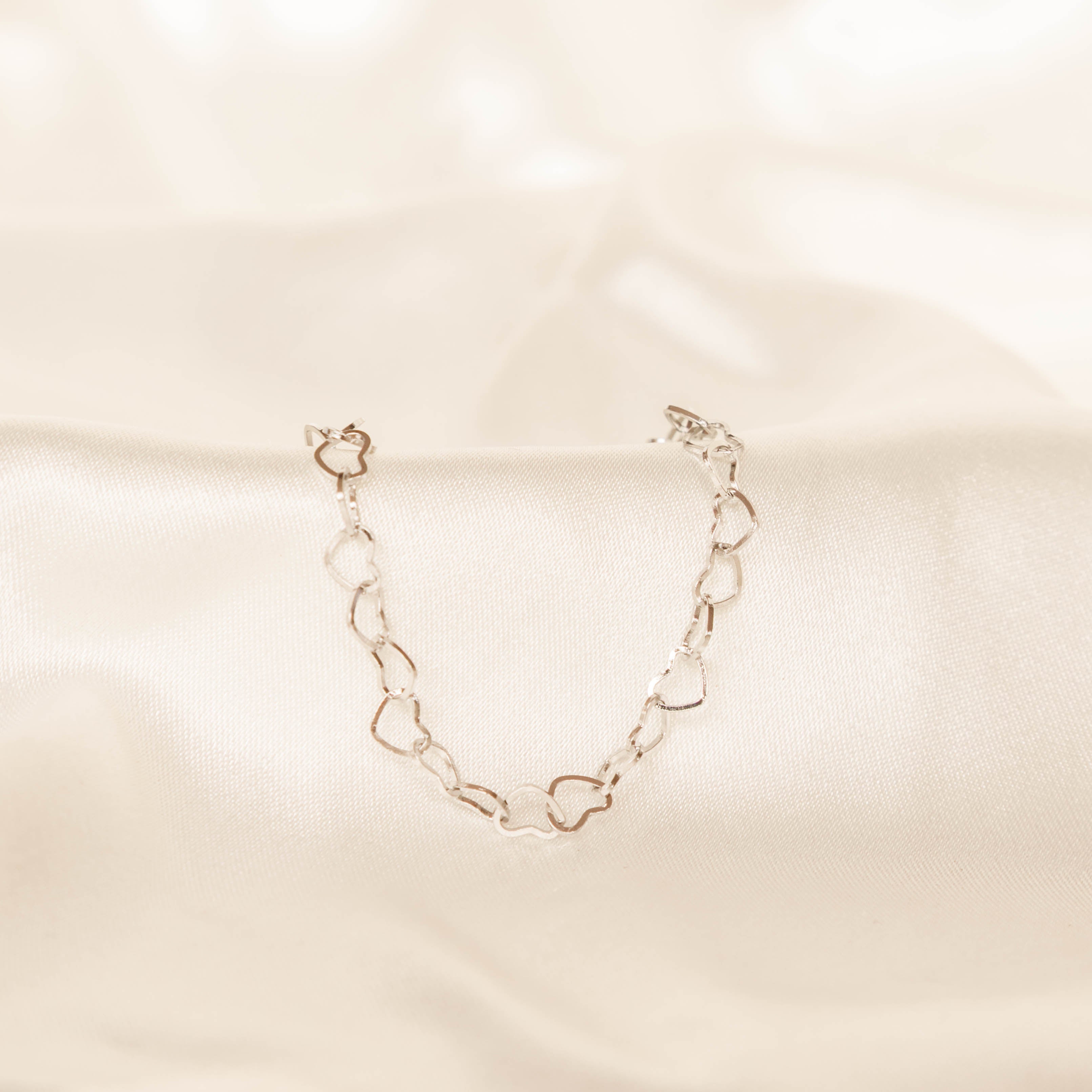 Silver chain bracelet on a beige fabric background