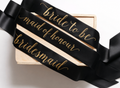 Black sash with gold text 'bride to be', 'maid of honour', and 'bridesmaid' on a white background.