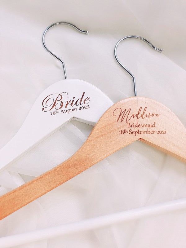 Two personalised engraved hangers for a bride and bridesmaid on a white background