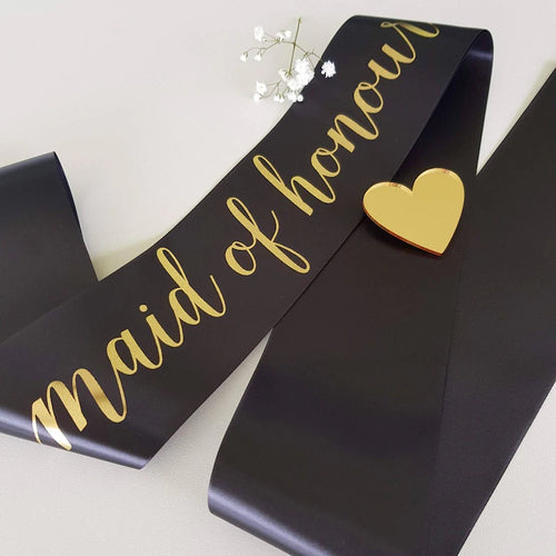 Black sash with gold 'maid of honour' text and heart design on a light background
