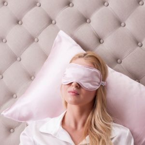 woman wearing pink mulberry silk eye pillow