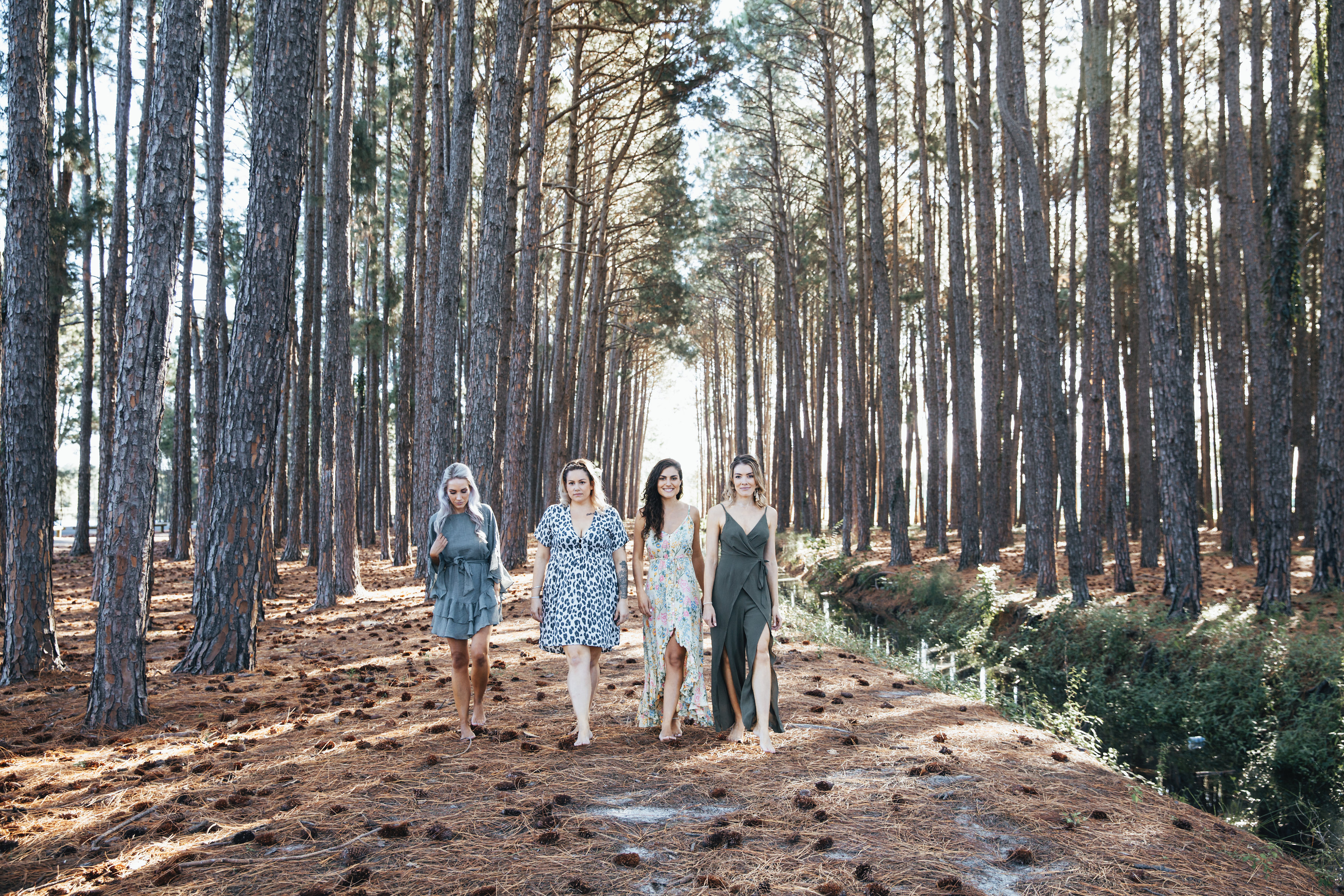 bridesmaids walking together through forest