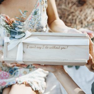 Bride to be handing a bridesmaid a keepsake gift box that reads "I can't say I do without you" for her bridesmaid proposal