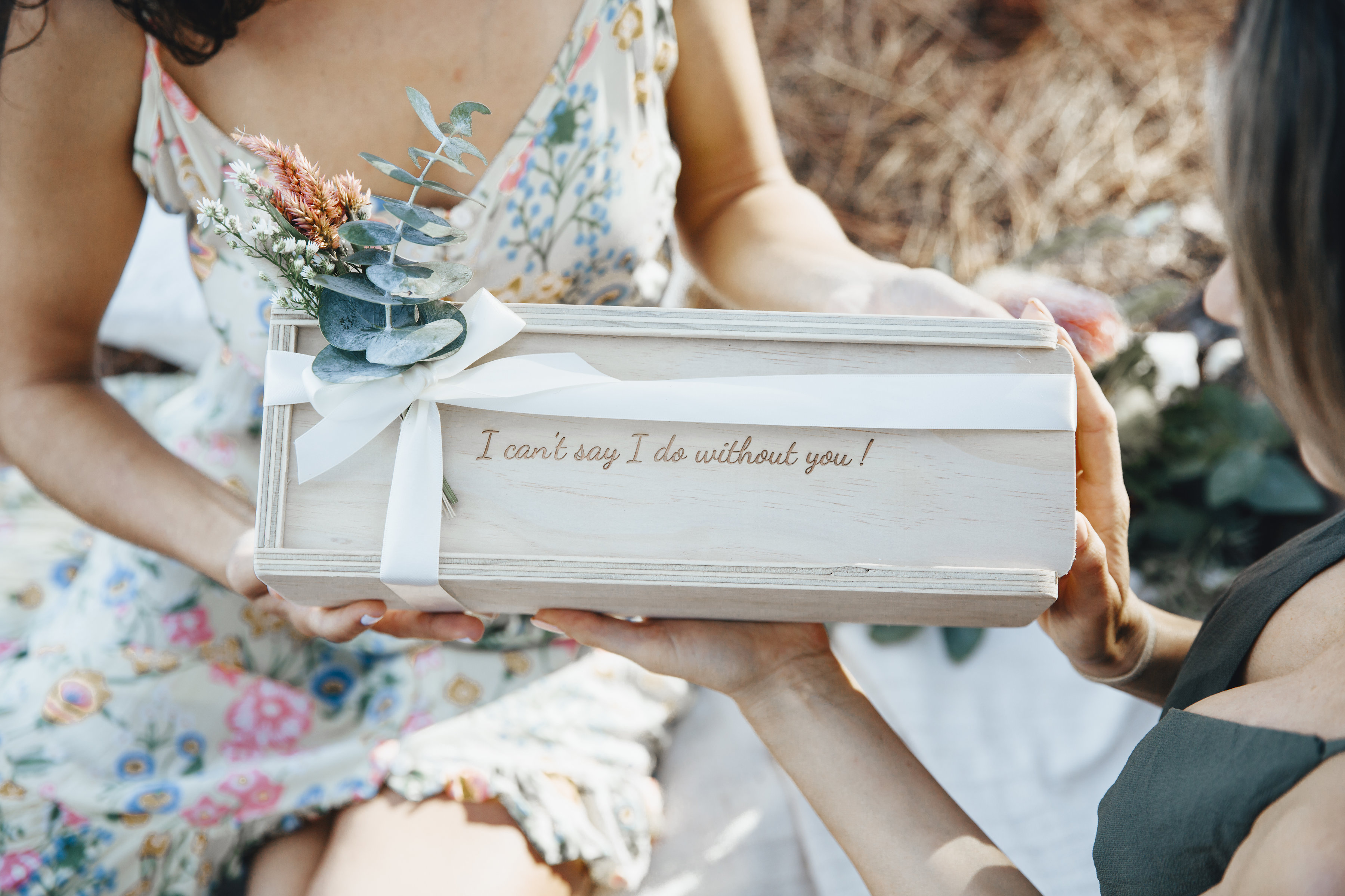 Bride to be handing a bridesmaid a keepsake gift box that reads "I can't say I do without you" for her bridesmaid proposal