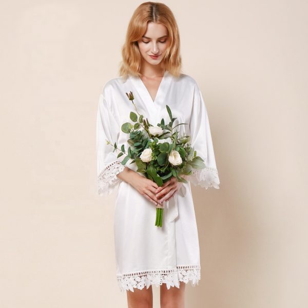 woman wearing white bridal party robe bride robe and bouquet