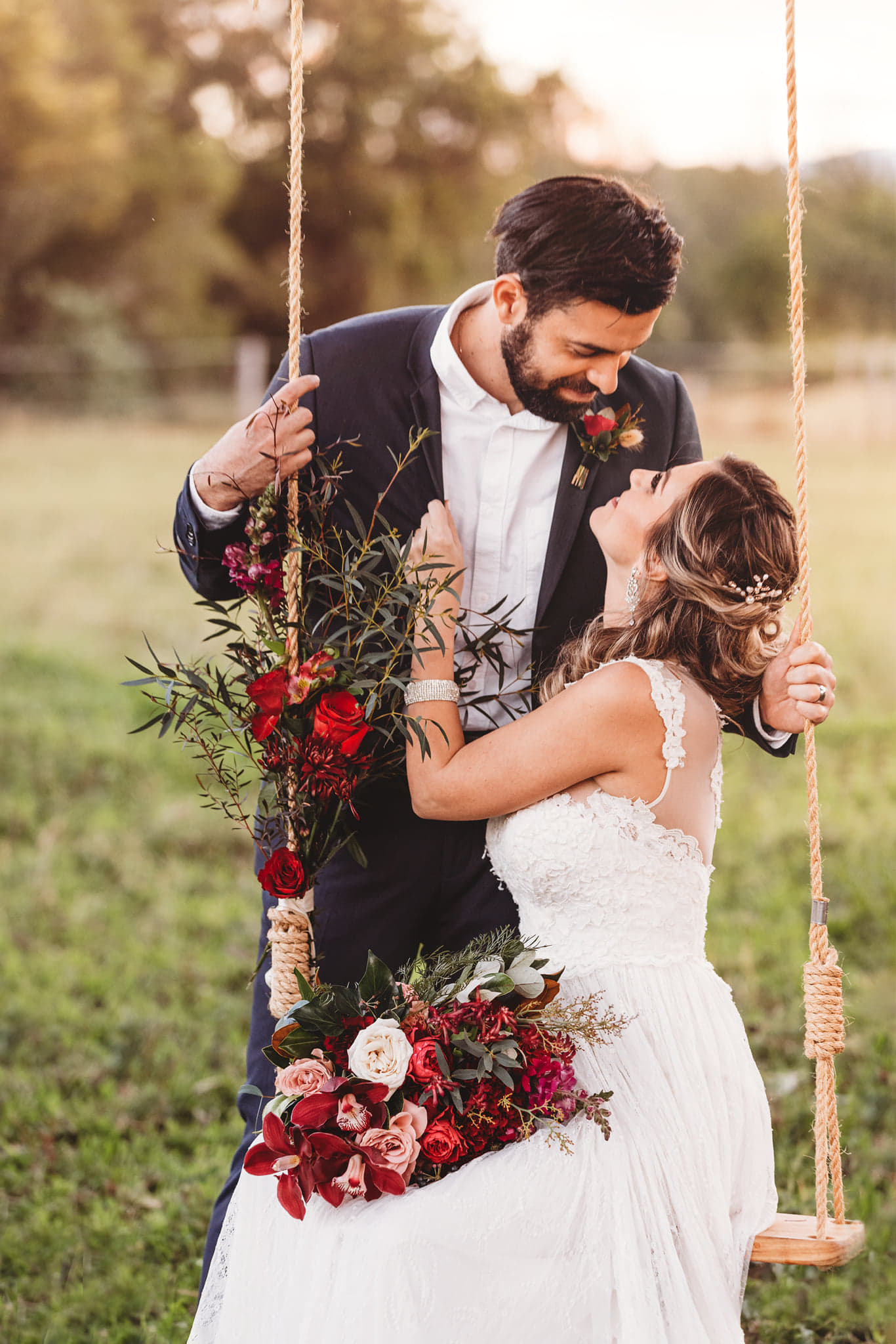 bride and groom on custom wooden wedding swing