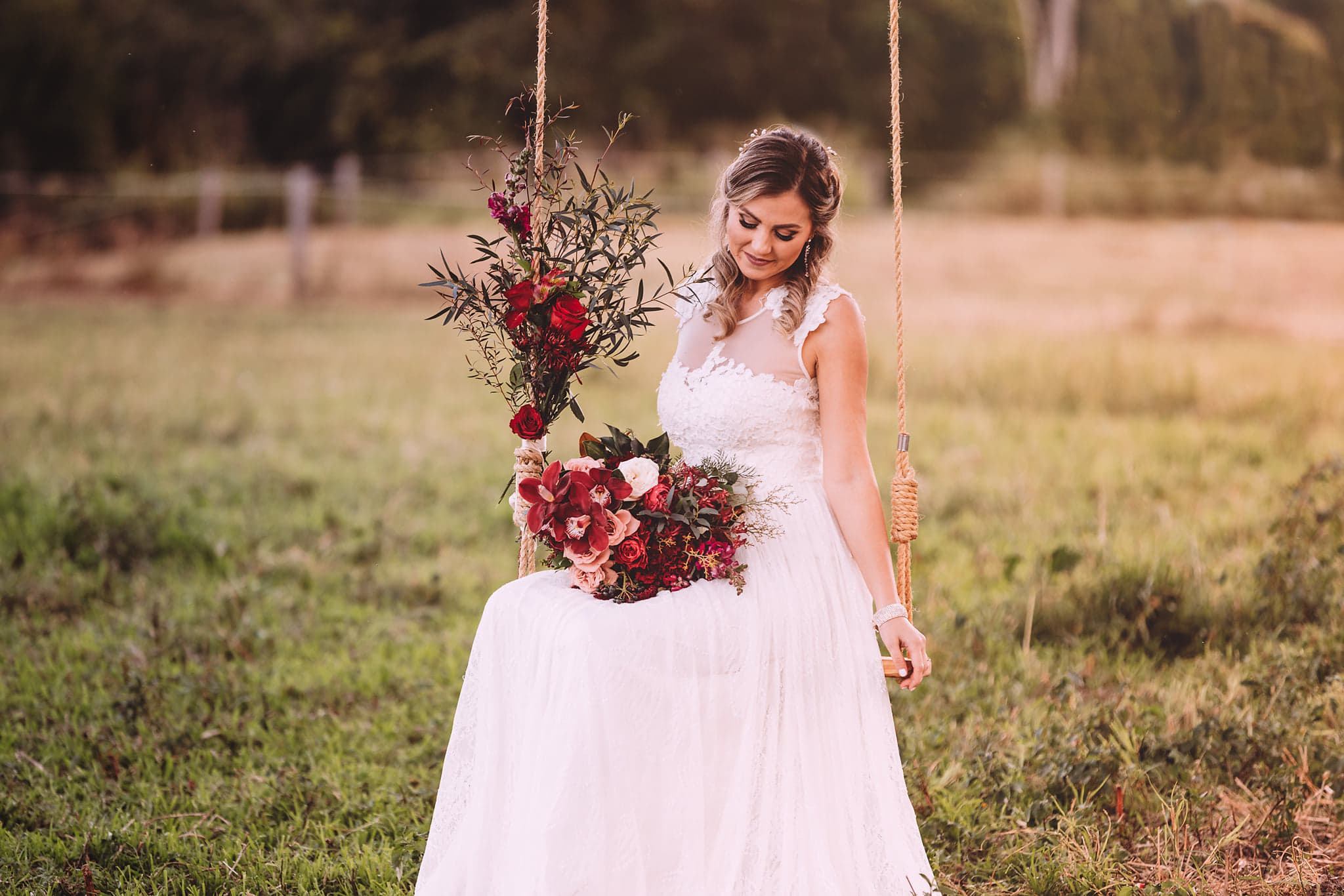 bride with vibrant bouquet on wooden swing