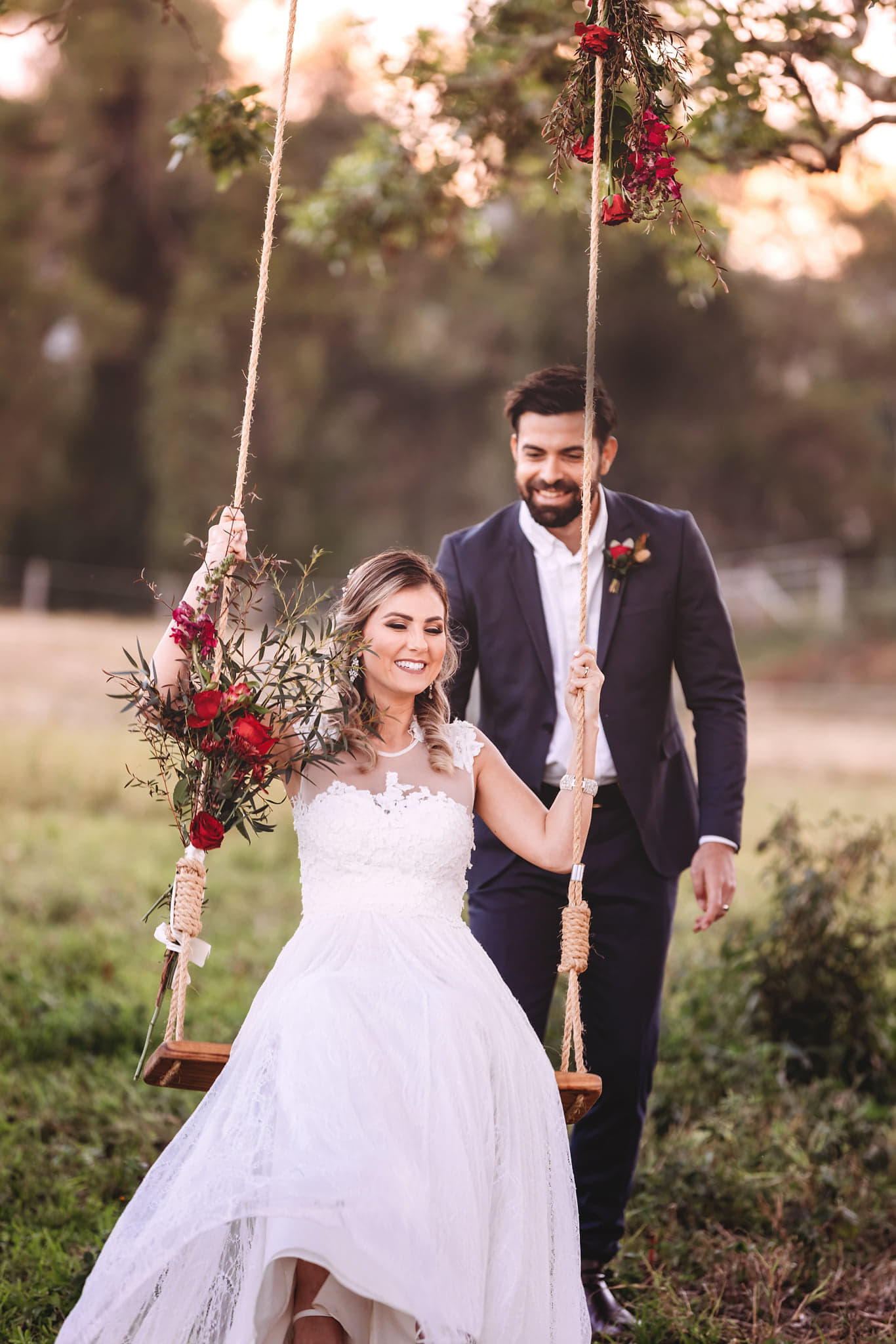 Bride and Groom swinging on custom wooden swing