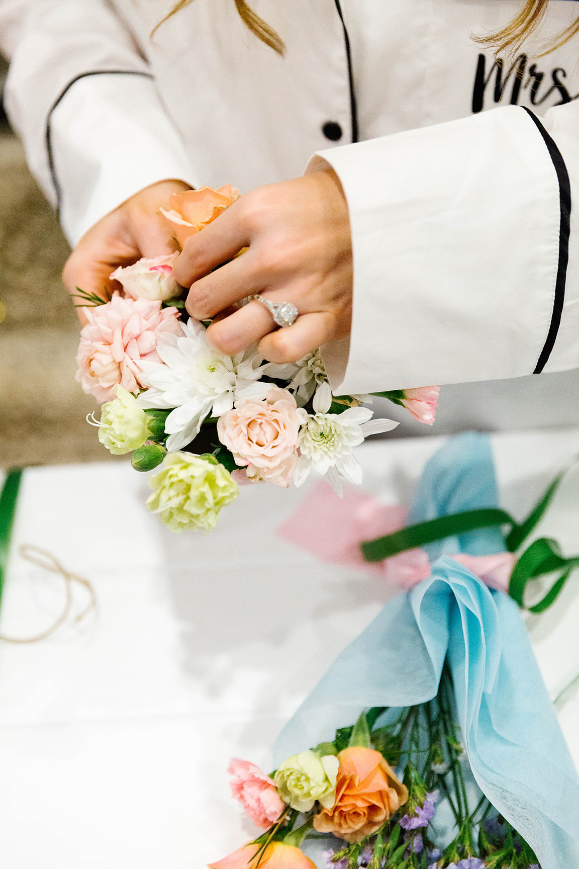 close up of hands arranging a posey of flowers