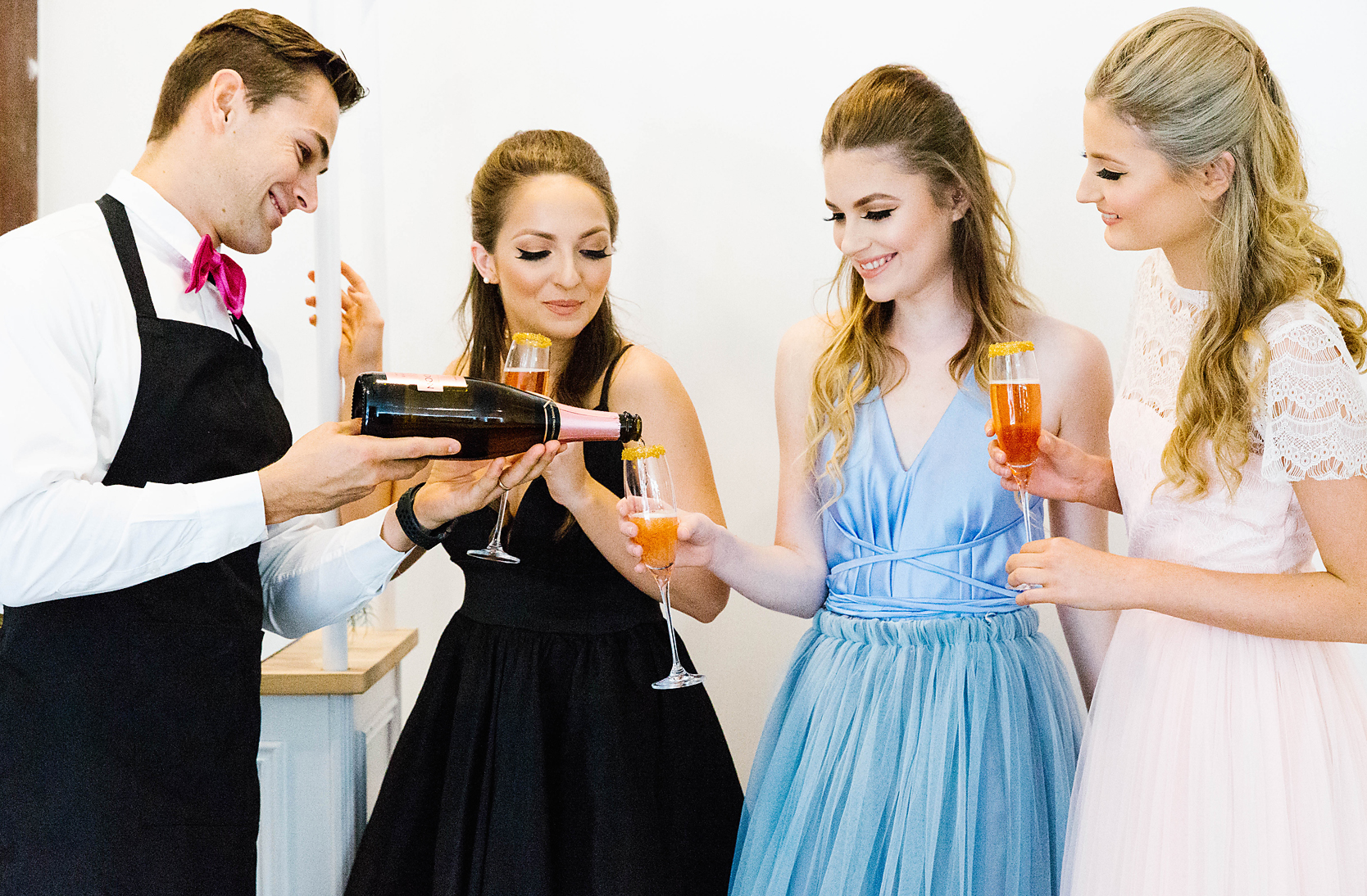 a personal waiter pouring sparking wine for hen's party attendees