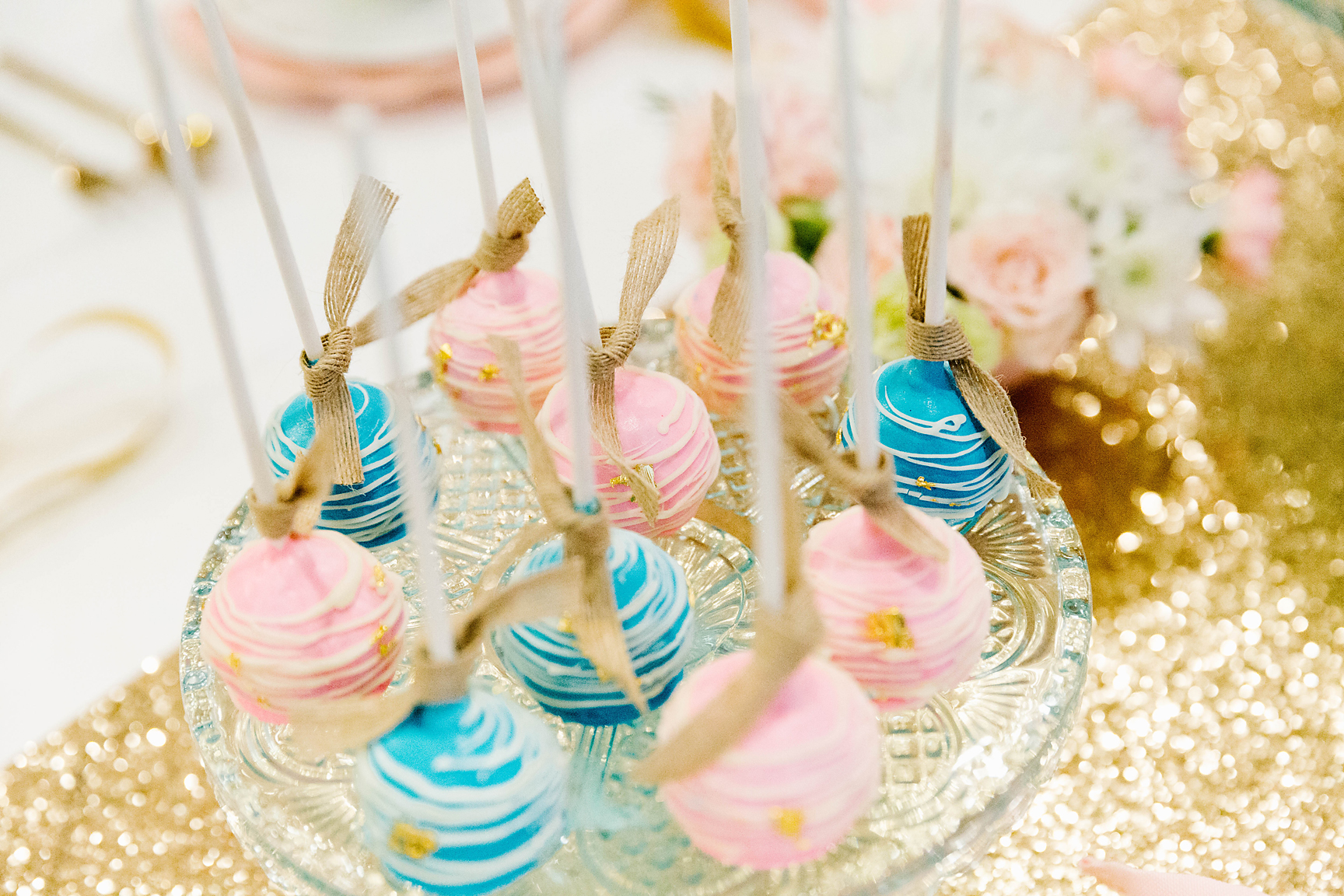 pink and blue cake pops on gold sequen table