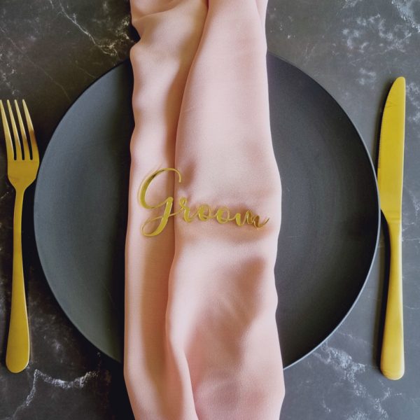 Groom acrylic name place card in mirror gold displayed on black plate with pink napkin and gold cutlery
