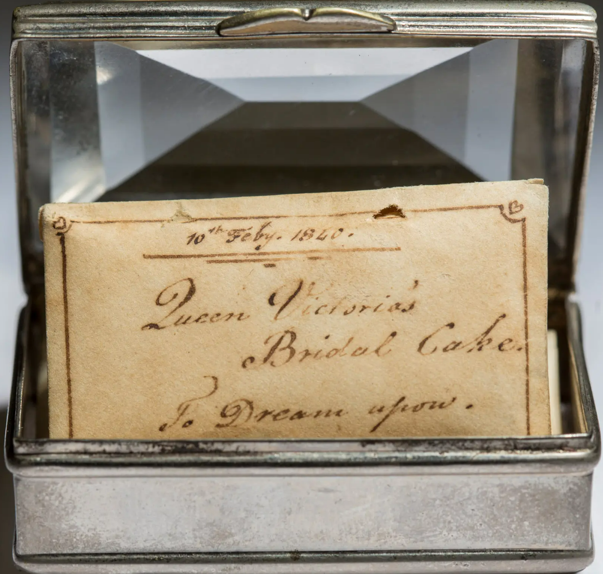A silvered box with a glass top containing a piece of cake from Queen Victoria’s wedding party.Credit...Fred R. Conrad for The New York Times