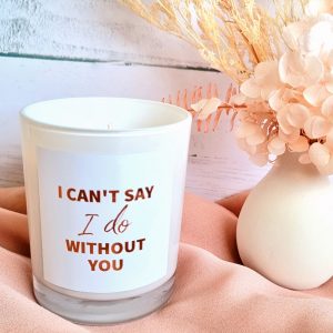 a medium soy candle by dried floral arrangement. candle reads "I can't say I do without you"