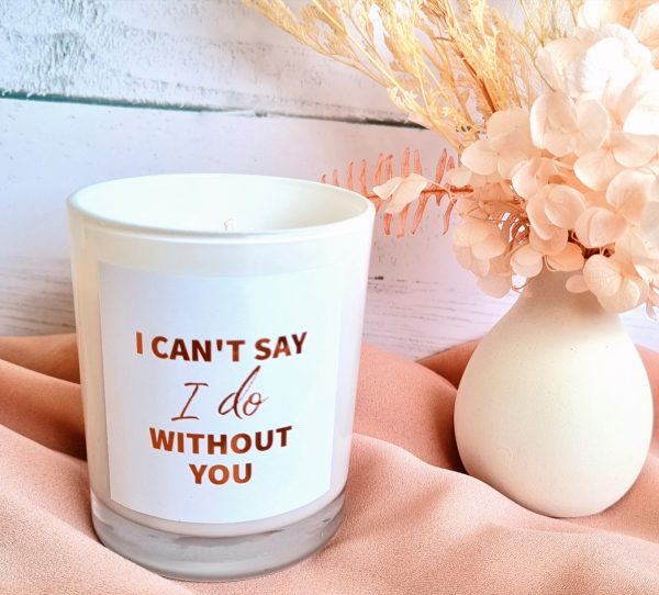 a medium soy candle by dried floral arrangement. candle reads "I can't say I do without you"