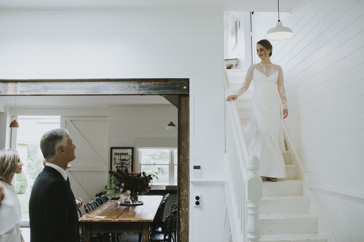 bride walking down stairwell toward her father