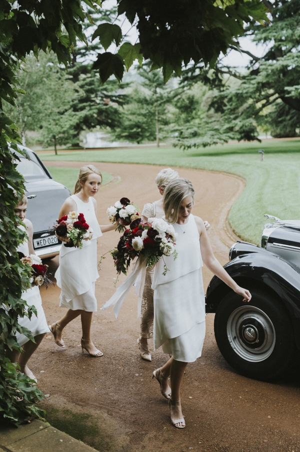 bridesmaids wearing white, making their way towards a wedding venue