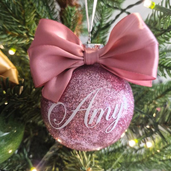 pink glitter bauble with pink bow and white name decal