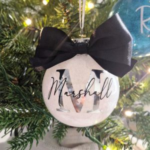 white bauble with black bow and silver initial on christmas tree